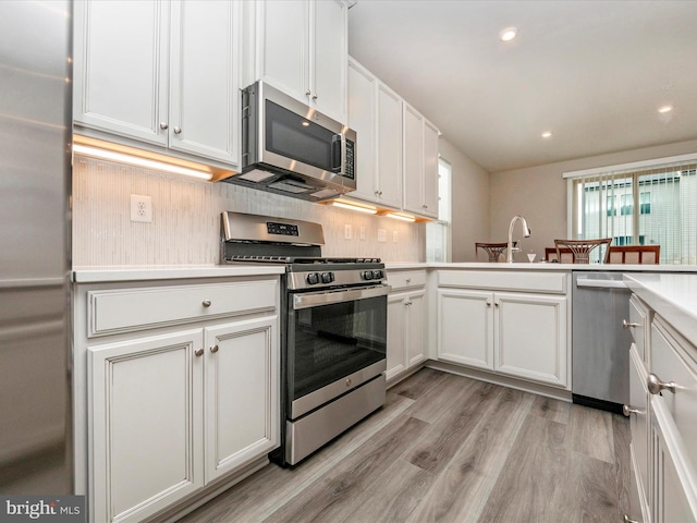 kitchen featuring white cabinets, light hardwood / wood-style floors, and stainless steel appliances