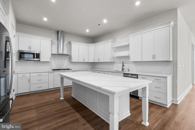 kitchen featuring wall chimney exhaust hood, white cabinetry, and stainless steel appliances