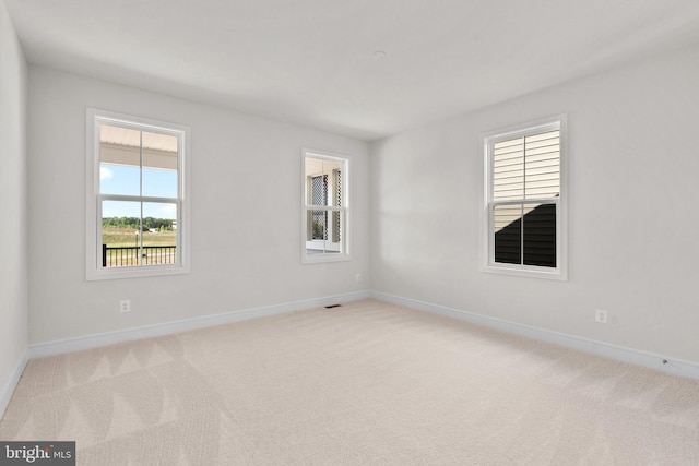 unfurnished room featuring light colored carpet