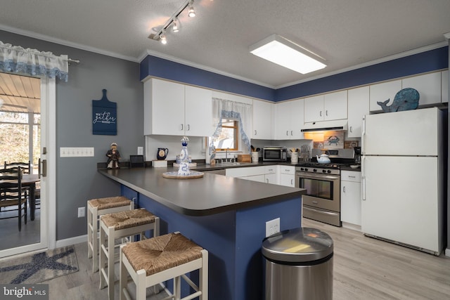 kitchen with white cabinets, white fridge, ornamental molding, and gas range