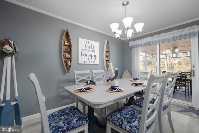 dining room featuring a chandelier, ornamental molding, a textured ceiling, and light wood-type flooring