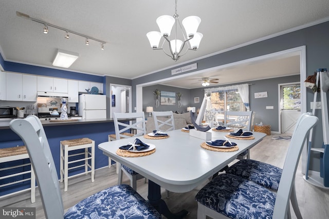 dining area featuring ceiling fan with notable chandelier, rail lighting, ornamental molding, a textured ceiling, and light hardwood / wood-style floors