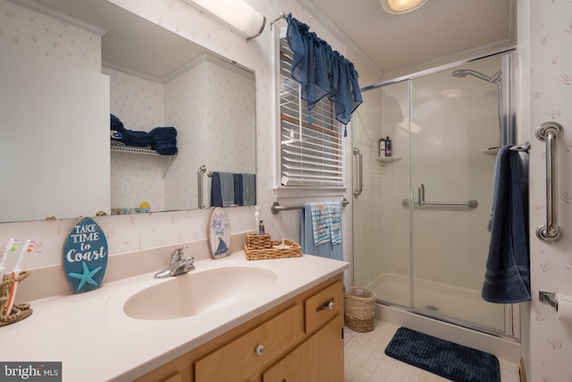 bathroom with vanity, an enclosed shower, ornamental molding, and a textured ceiling