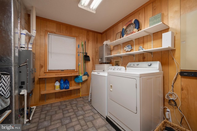 laundry area featuring wooden walls, washer and dryer, and ornamental molding