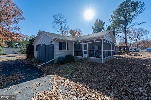 rear view of property featuring a sunroom