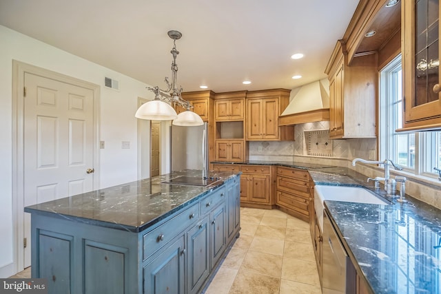 kitchen featuring a center island, dark stone countertops, pendant lighting, gray cabinets, and custom range hood