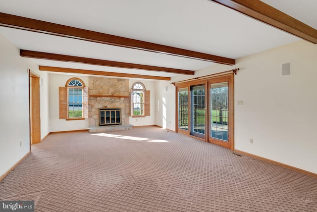 unfurnished living room with beamed ceiling, light colored carpet, and a fireplace