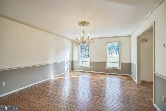 unfurnished dining area featuring light hardwood / wood-style flooring, ornamental molding, and an inviting chandelier