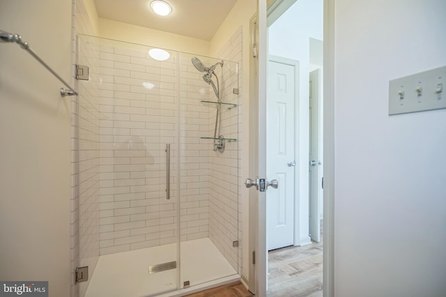 bathroom featuring hardwood / wood-style floors and a shower with door