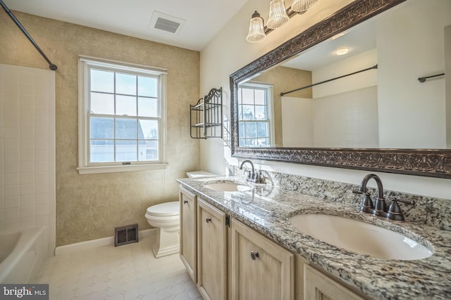 full bathroom with tile patterned flooring, vanity, tiled shower / bath combo, and toilet