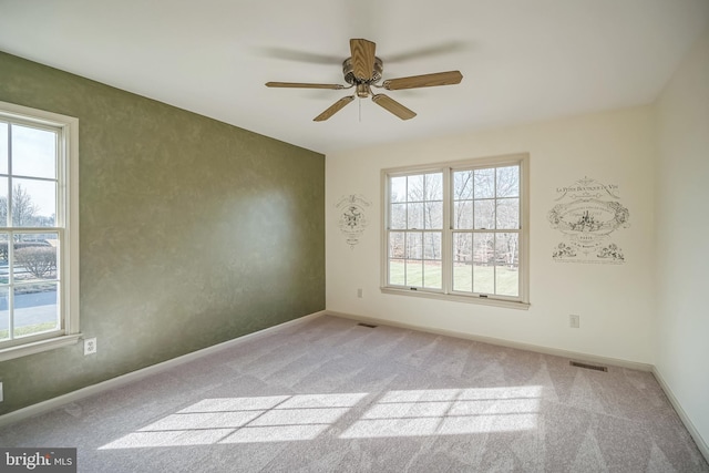 empty room with ceiling fan and light carpet