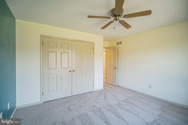 unfurnished bedroom with ceiling fan, a closet, and light carpet