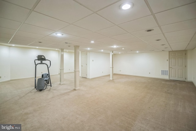 basement featuring a paneled ceiling and light carpet