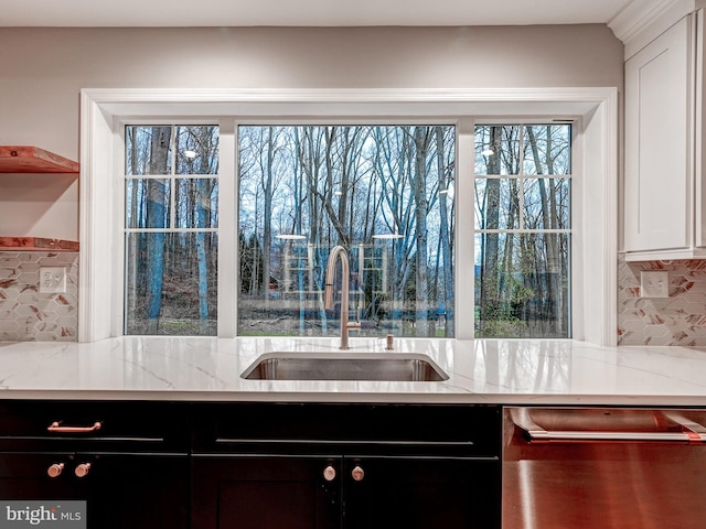 kitchen featuring white cabinetry, light stone countertops, sink, and stainless steel dishwasher