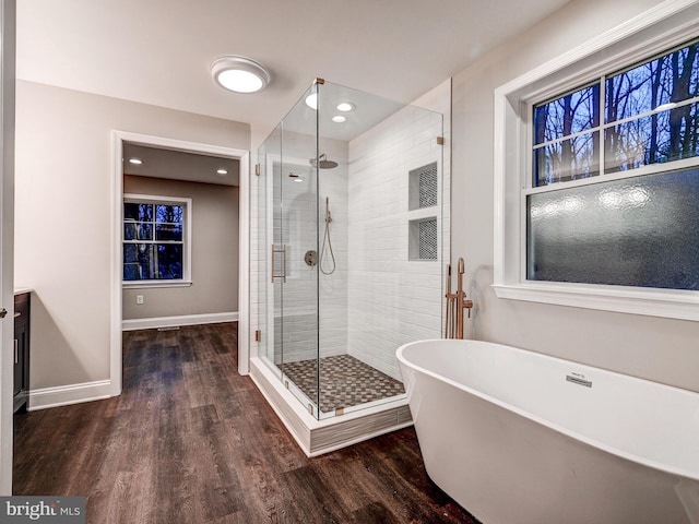 bathroom with hardwood / wood-style floors and separate shower and tub