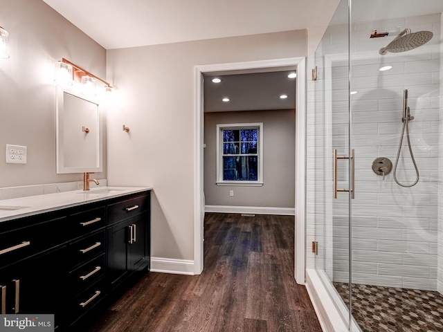 bathroom with vanity, wood-type flooring, and a shower with shower door