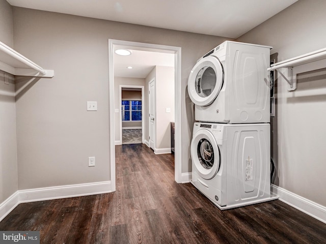 laundry area featuring dark hardwood / wood-style floors and stacked washer / drying machine