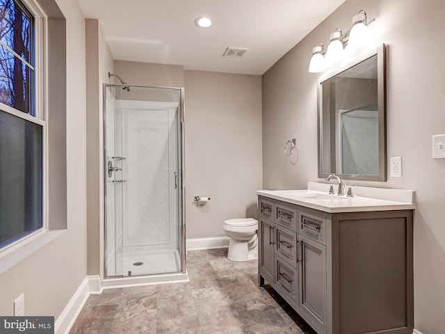 bathroom with vanity, a shower with shower door, and toilet