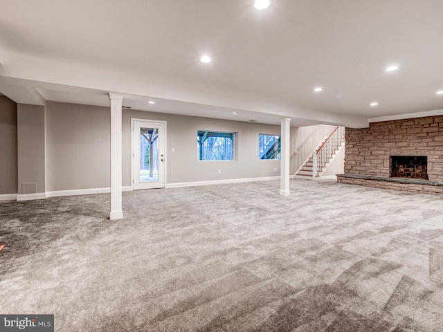 basement with carpet floors and a stone fireplace