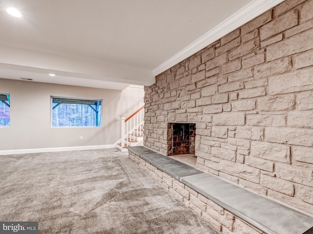 unfurnished living room featuring carpet flooring, crown molding, and a fireplace