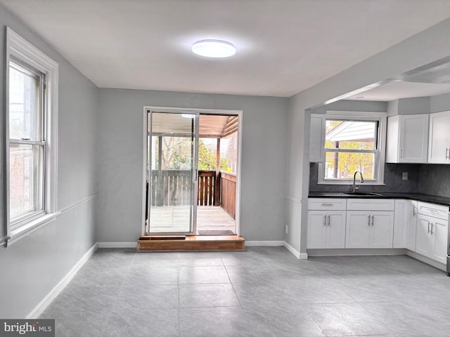 interior space featuring a healthy amount of sunlight, light tile patterned floors, and sink