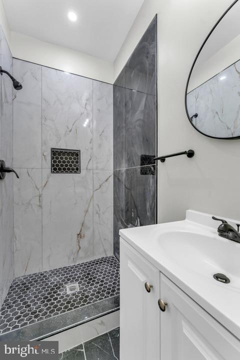 bathroom featuring a tile shower and vanity