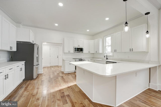 kitchen with kitchen peninsula, appliances with stainless steel finishes, white cabinetry, and light hardwood / wood-style flooring