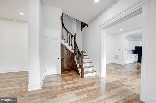 foyer featuring light hardwood / wood-style floors and ornamental molding