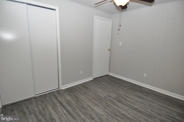 unfurnished bedroom featuring dark hardwood / wood-style flooring, a closet, ceiling fan, and crown molding