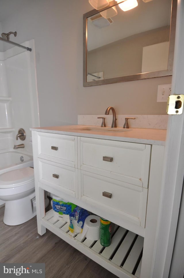 full bathroom featuring vanity, wood-type flooring, tub / shower combination, and toilet