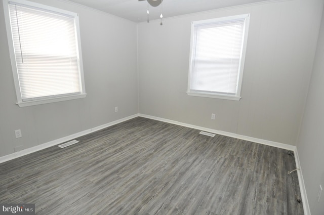 unfurnished room with crown molding, ceiling fan, and dark wood-type flooring