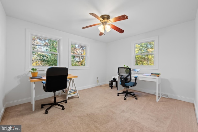 office area with light carpet, ceiling fan, and a healthy amount of sunlight