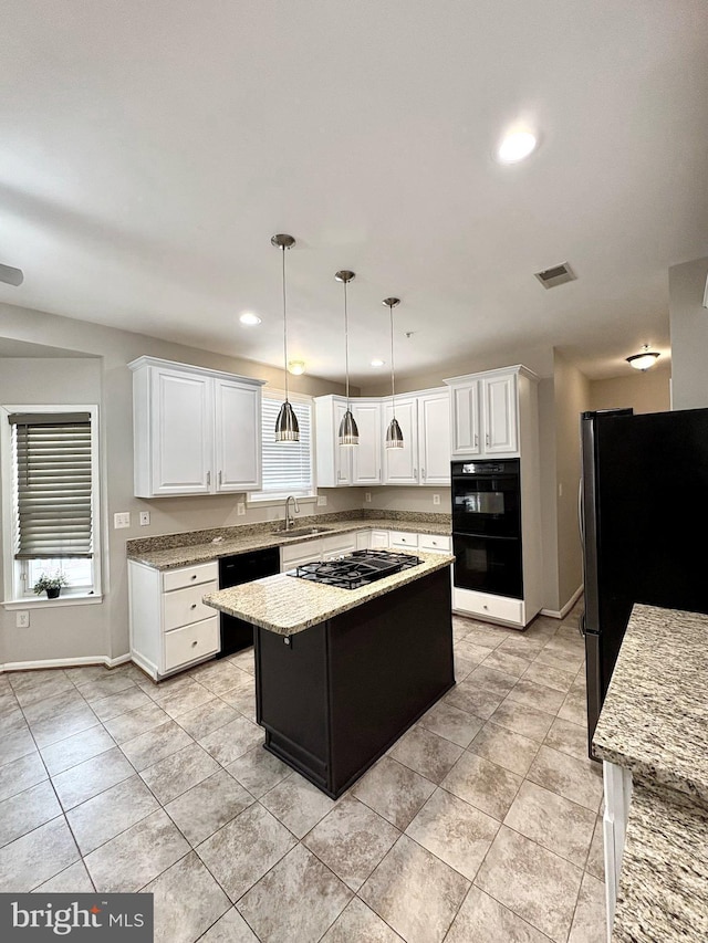 kitchen with hanging light fixtures, a center island, white cabinets, and black appliances