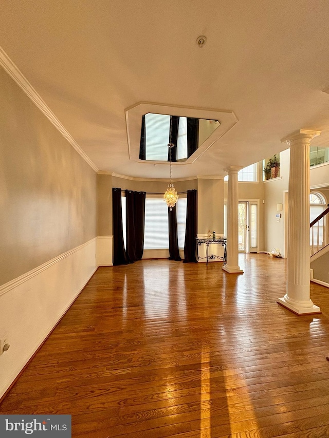 spare room with crown molding, hardwood / wood-style floors, and ornate columns