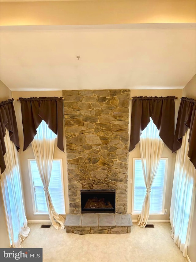 unfurnished living room featuring carpet, a wealth of natural light, and a fireplace