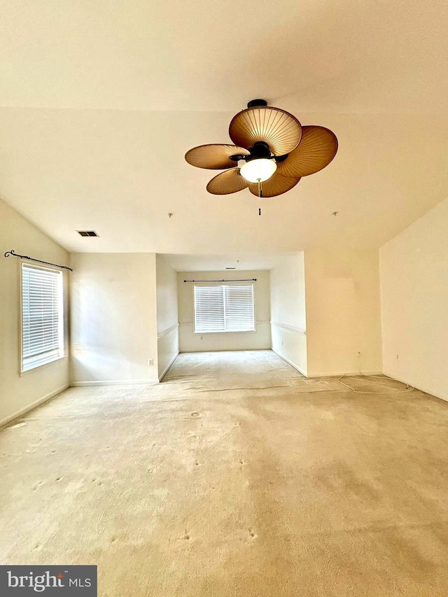 unfurnished living room featuring carpet, a wealth of natural light, and ceiling fan