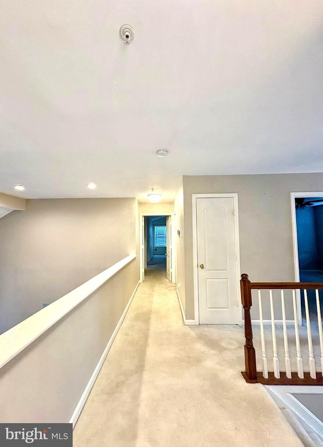 hallway featuring light colored carpet