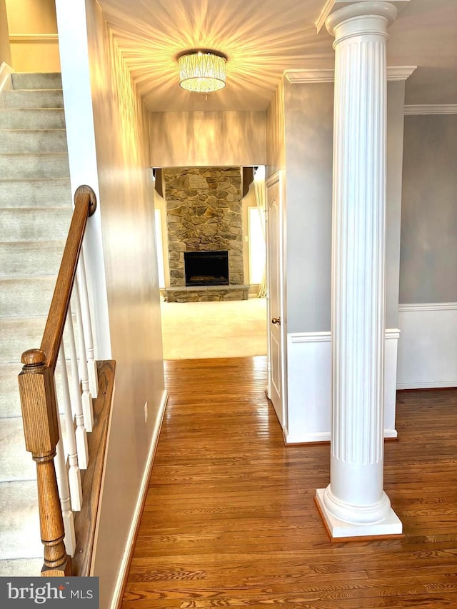 hall with hardwood / wood-style flooring, ornamental molding, and ornate columns