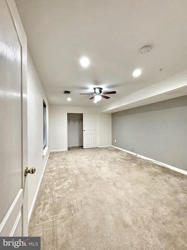 basement with ceiling fan and carpet floors