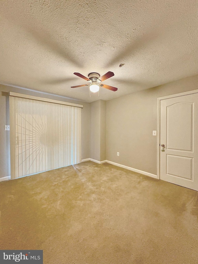 spare room with carpet flooring, a textured ceiling, and ceiling fan