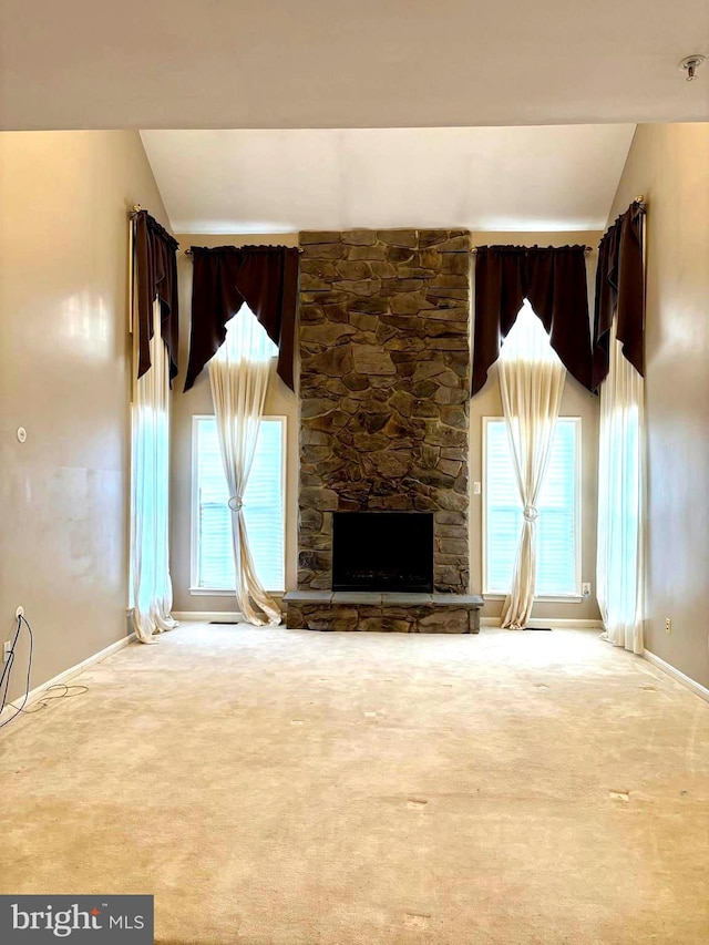 unfurnished living room with a fireplace, high vaulted ceiling, and carpet