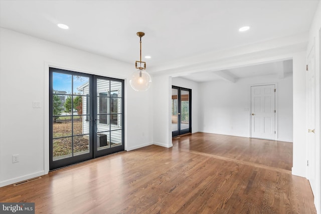 unfurnished room featuring french doors, beamed ceiling, and hardwood / wood-style floors