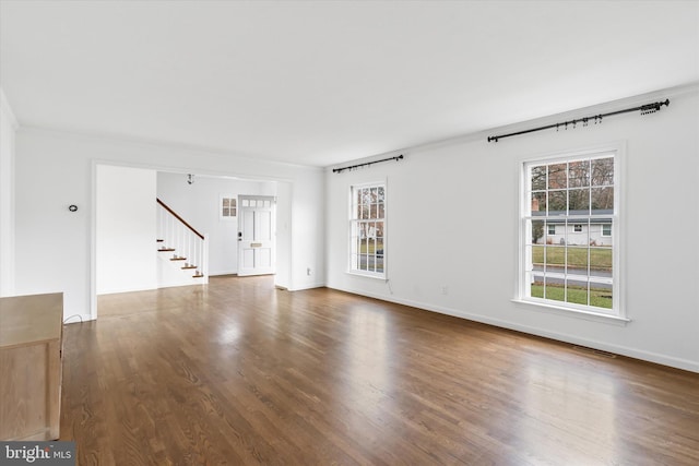 spare room with crown molding and dark wood-type flooring