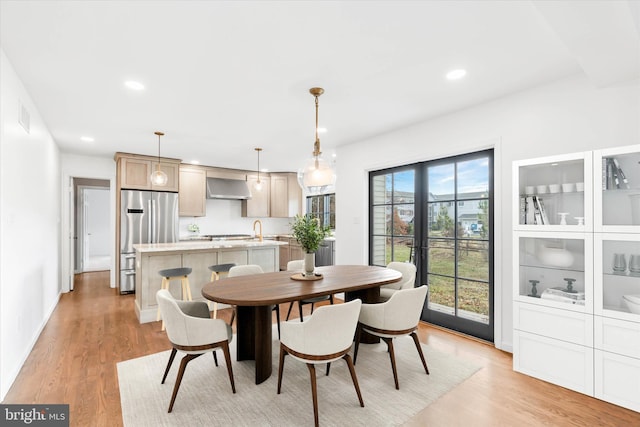 dining area featuring sink and light wood-type flooring