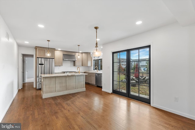 kitchen featuring wall chimney range hood, decorative light fixtures, a kitchen island, dark hardwood / wood-style flooring, and stainless steel appliances