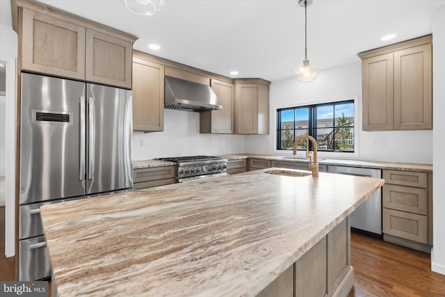 kitchen with pendant lighting, wall chimney range hood, sink, dark hardwood / wood-style floors, and appliances with stainless steel finishes