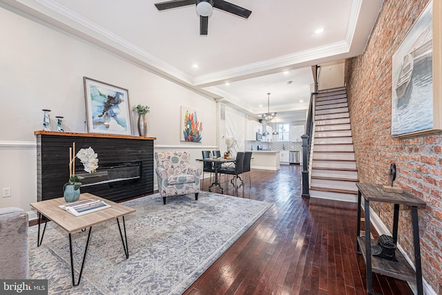 living room featuring dark hardwood / wood-style flooring, ceiling fan, and ornamental molding