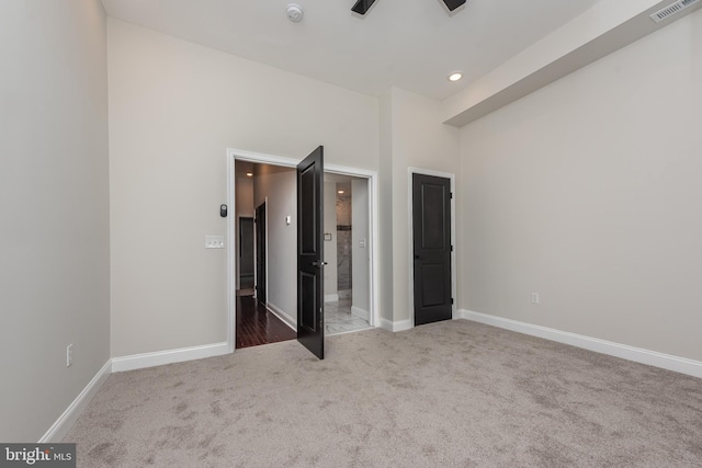 unfurnished bedroom featuring carpet flooring and a towering ceiling