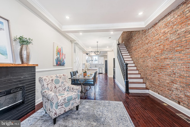 interior space with dark hardwood / wood-style flooring, ornamental molding, and brick wall