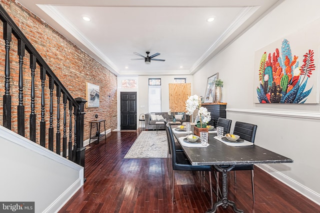 dining space featuring ceiling fan, dark wood-type flooring, brick wall, and ornamental molding